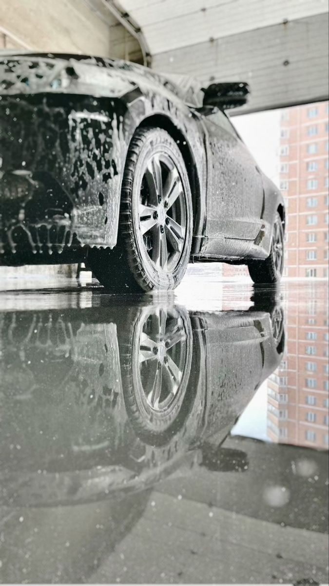 Auto con espuma y reflejo en el piso del garage