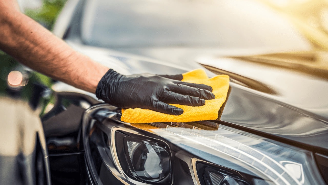 Detallado de autos en Milpa Alta: Mano con guante negro y microfibra sobre faro