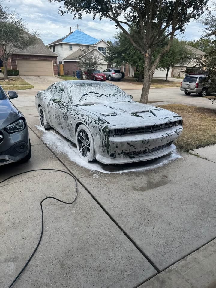 Dodge Challenger con espuma frente a casa