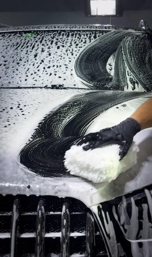 Lavado detallado de autos: Guante de lavado con espuma sobre cofre negro