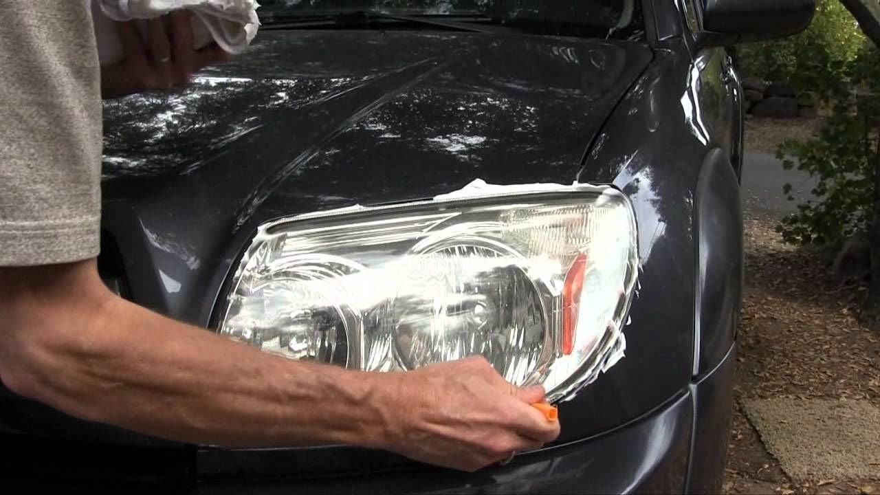 Pulido de faros: Pulido a mano de faro con crema sobre auto gris oscuro