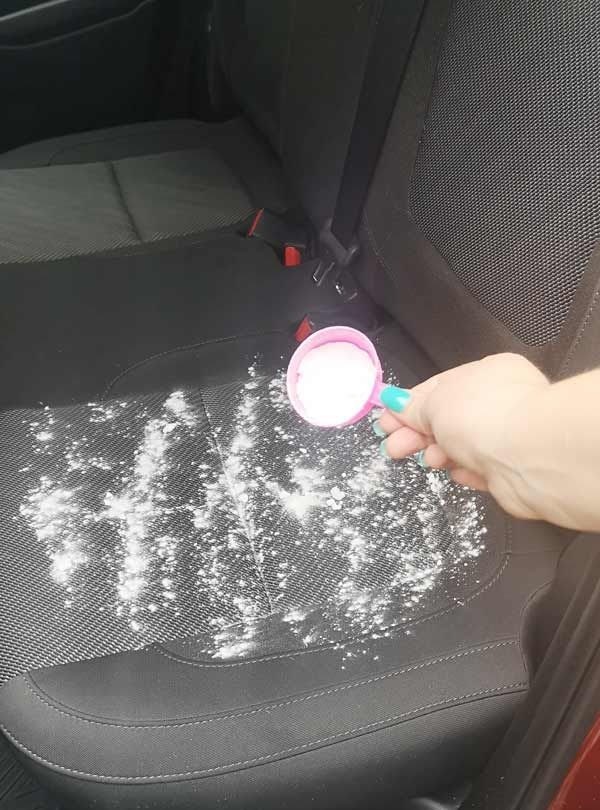 Aplicando limpiador en polvo a asiento de tela
