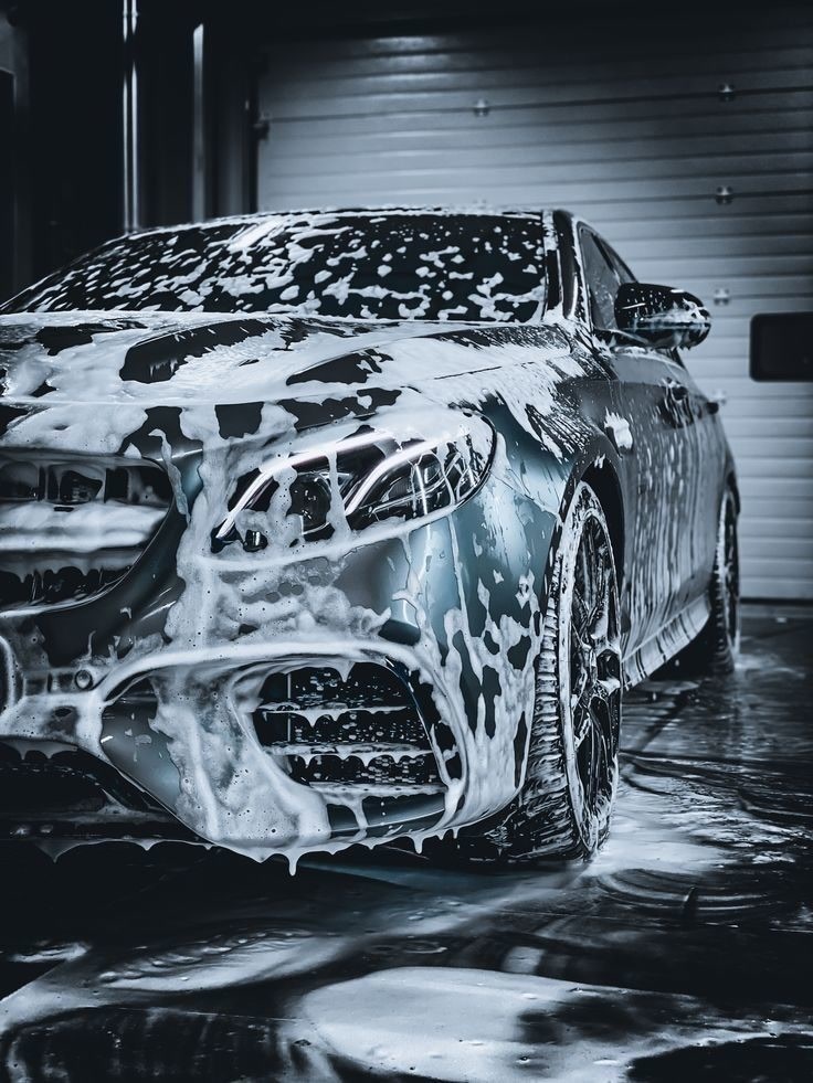 Mercedes cubierto de espuma en garage oscuro