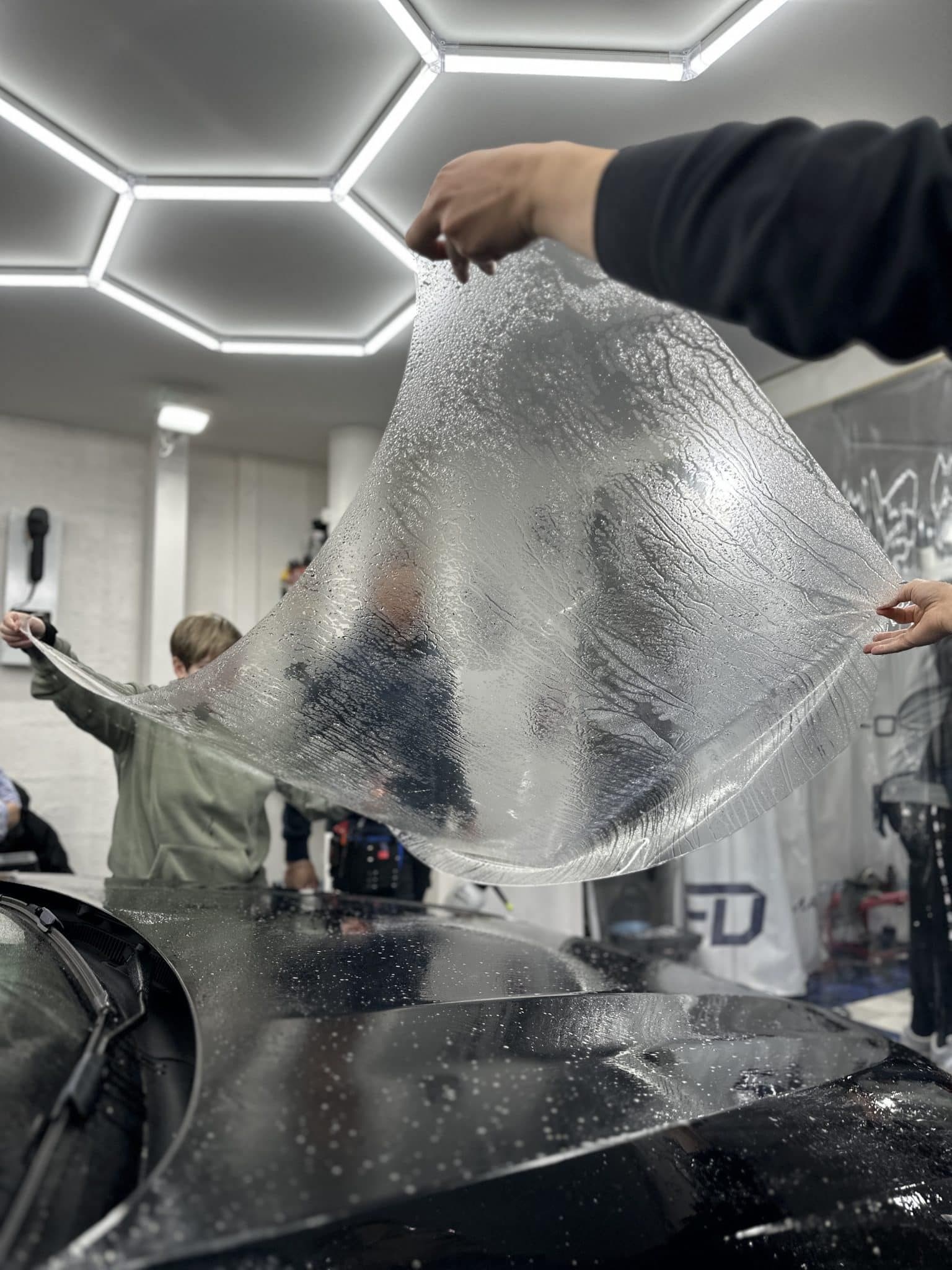 Película PPF levantada en taller con luces hexagonales