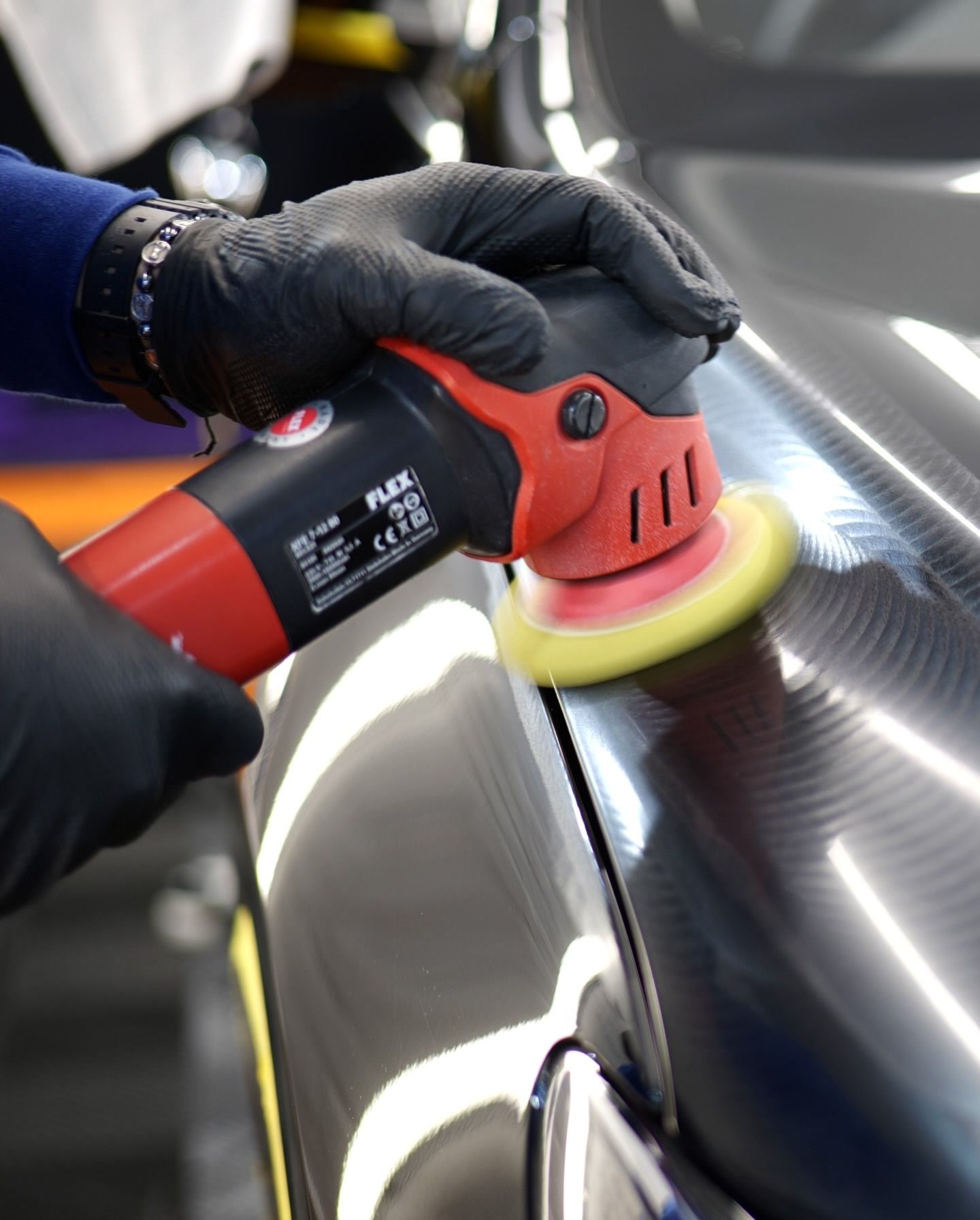 Pulido con máquina y guantes negros, primer plano