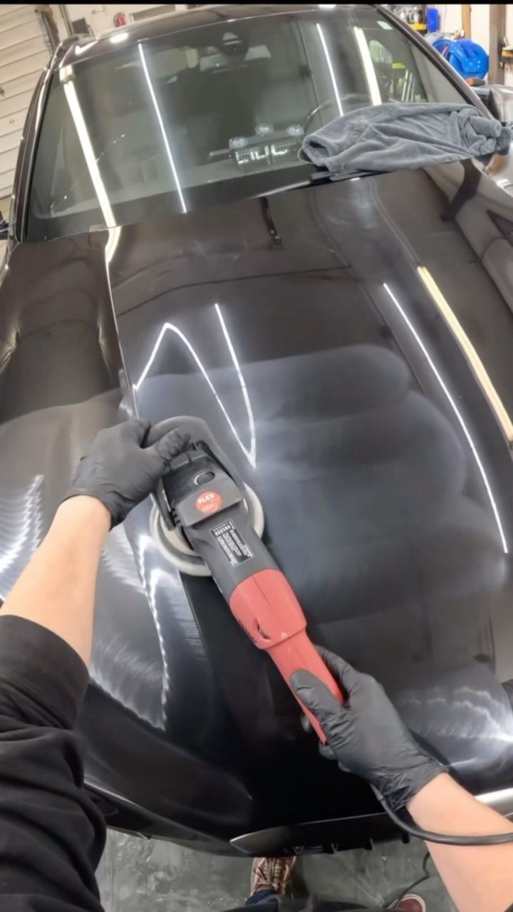 Pulido de autos: Pulidora roja sobre capó negro (vista en primera persona)